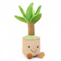 Peluche kawaii a forma di yucca in vaso sorridente, con piedini marroni, su sfondo bianco.