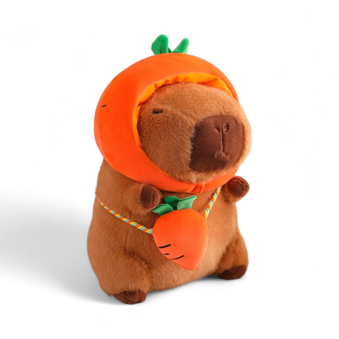 Peluche capybara marrone con un cappellino a forma di carota e un sacchetto coordinato, su sfondo bianco.