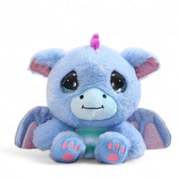 Piccolo peluche drago blu con ali scintillanti, cresta rosa e grandi occhi brillanti, su sfondo bianco.