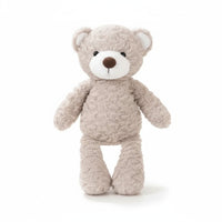 Orsetto di peluche beige chiaro, musetto bianco, naso marrone, piccoli occhi neri, orecchie rotonde, texture riccia molto morbida; su sfondo bianco