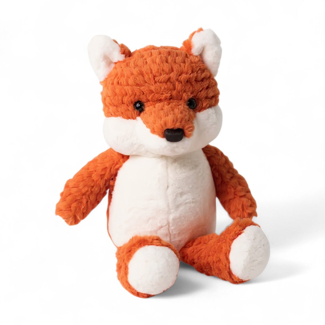 Volpe di peluche rosso e bianca, muso nero, orecchie dritte, seduta su sfondo bianco.