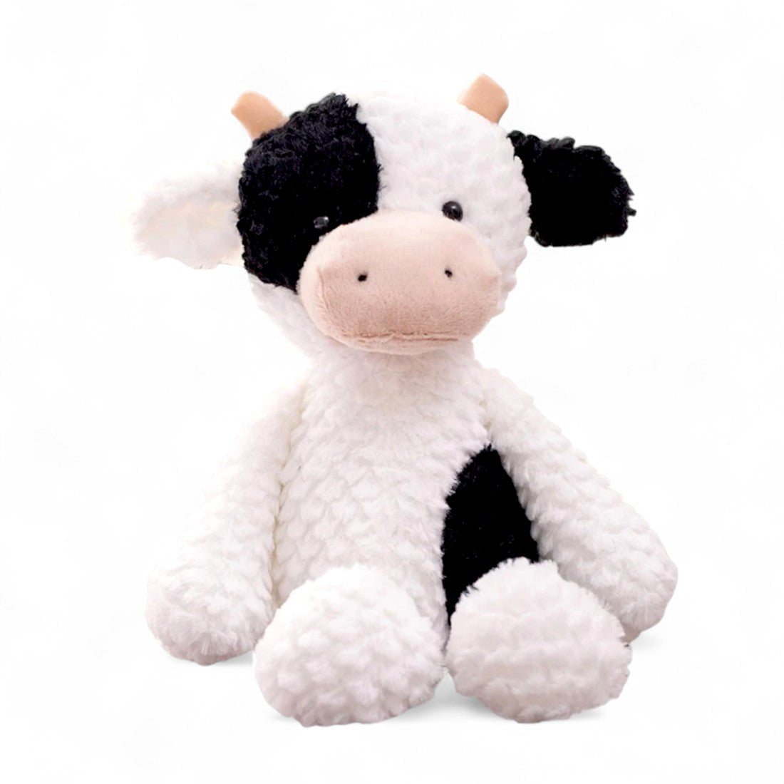 Mucca di peluche bianco a macchie nere, con muso beige e corna corte, seduta su sfondo bianco.