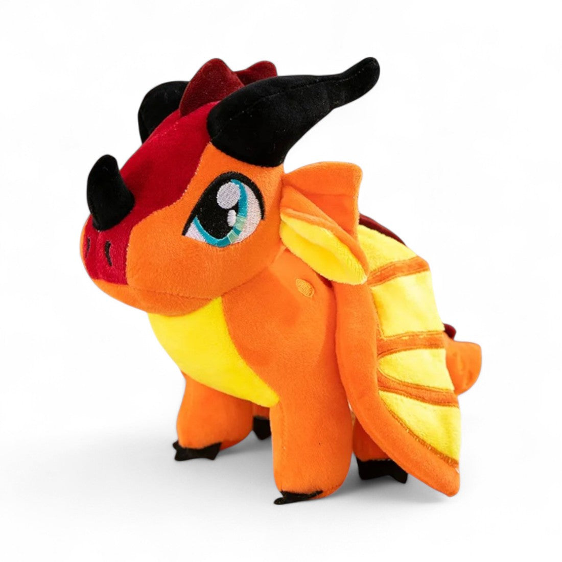 Piccolo drago di peluche arancione vivo, corna nere, grandi occhi turchesi, ali gialle a righe arancioni, cresta rossa, posizione eretta, su sfondo bianco