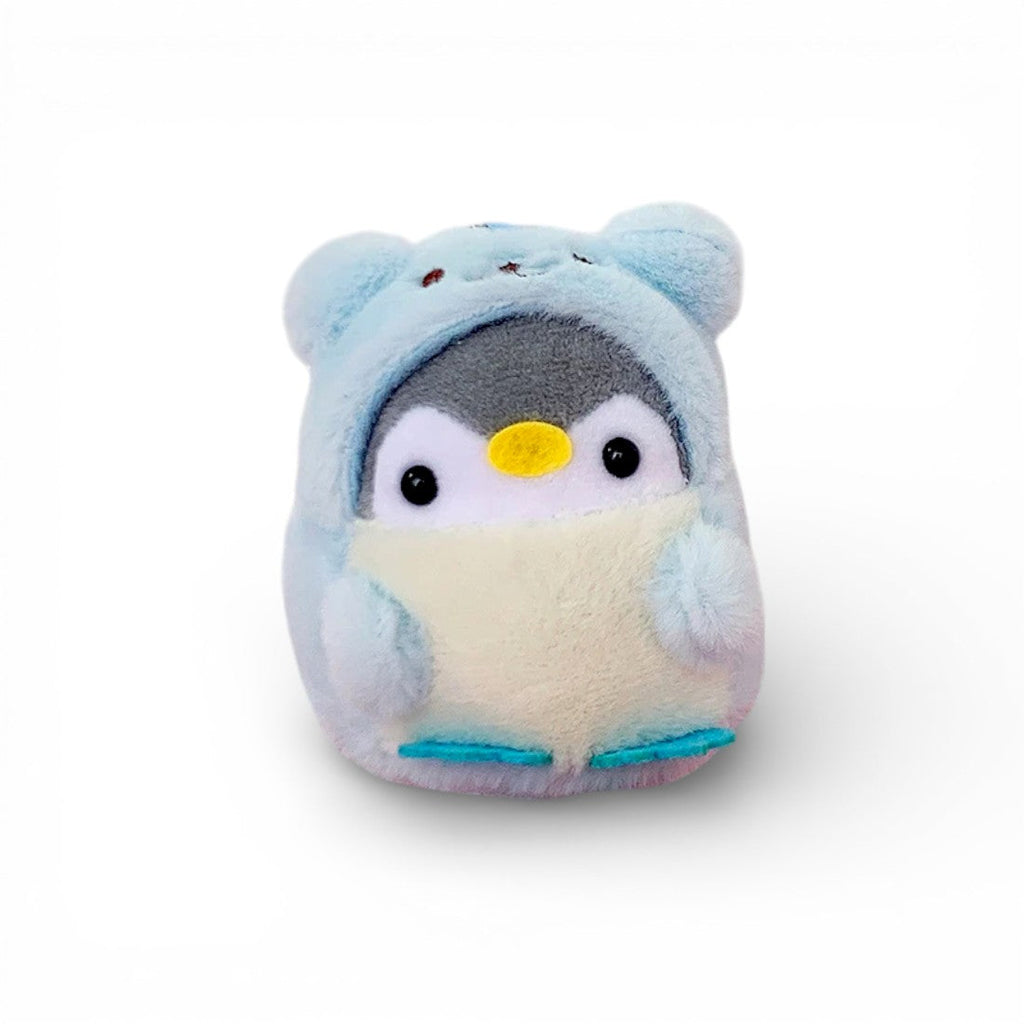 Un piccolo pinguino blu soffice travestito da orsetto, occhi rotondi neri brillanti, becco giallo in feltro, pancia beige, zampe blu, su sfondo bianco uniforme.